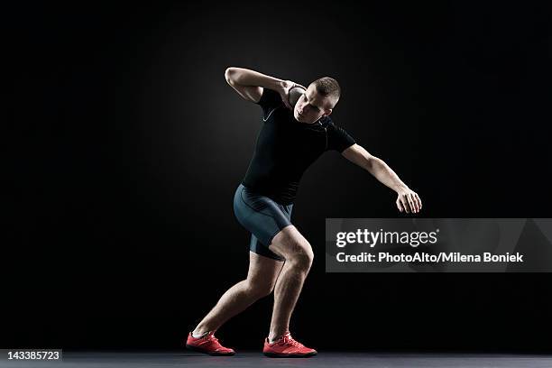 shot putter preparing to throw shot - kugelstoßen stock-fotos und bilder