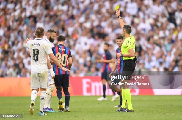 Referee Jose Maria Sanchez Martinez shows a yellow card to Gavi of FC Barcelona during the LaLiga Santander match between Real Madrid CF and FC...