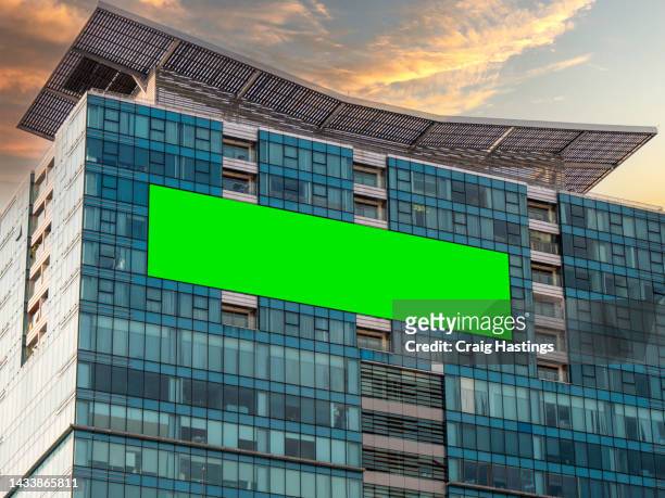 large to medium downtown urban city center building with green screen chroma key advertising billboards. large to medium size green screen chroma key marketing advertisement targeting adverts at consumers, retail shoppers, commuters and tourists. - display window stock-fotos und bilder