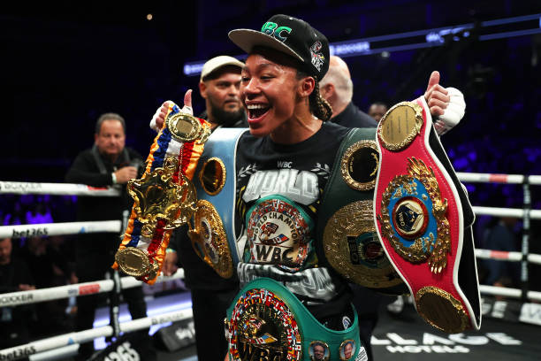 Alycia Baumgardner celebrates with the IBF, IBO, WBC and WBO Super Featherweight World Title Belts after victory in the IBF, IBO, WBC and WBO Super...