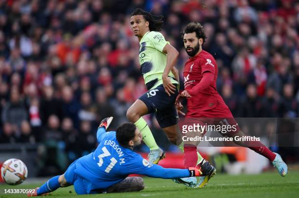 Ederson of Manchester City makes a save from the shot of Mohamed Salah of Liverpool as Nathan Ake looks on during the Premier League match between...