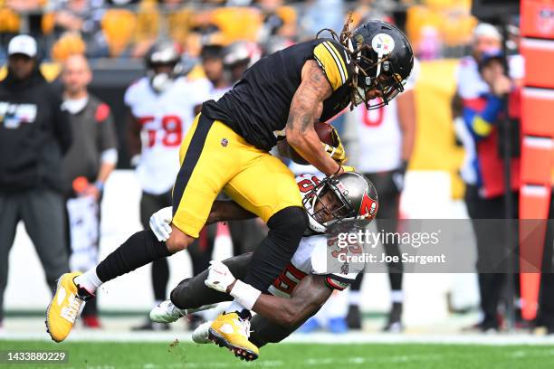 Jamel Dean of the Tampa Bay Buccaneers tackles Chase Claypool of the Pittsburgh Steelers during the first quarter at Acrisure Stadium on October 16,...