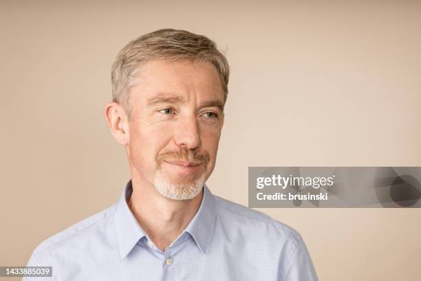 close up studio portrait of white 50 year old man with beard on beige background - portrait beige background stock pictures, royalty-free photos & images