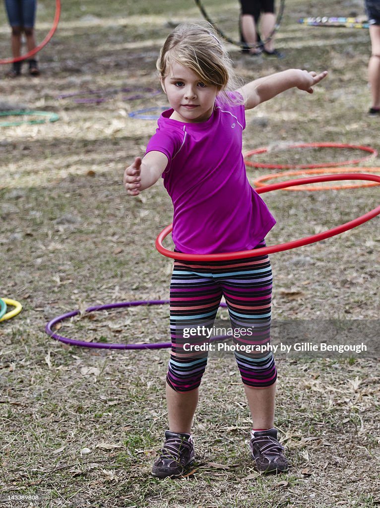 Girl playing with plastic hoop in garden