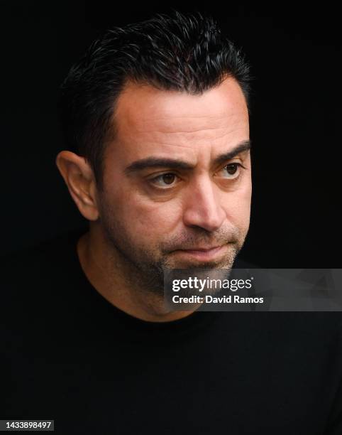 Head coach Xavi Hernandez of FC Barcelona looks down prior to the LaLiga Santander match between Real Madrid CF and FC Barcelona at Estadio Santiago...