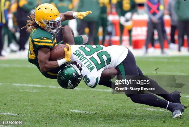 Aaron Jones of the Green Bay Packers gets tackled by Quincy Williams of the New York Jets in the third quarter of a game at Lambeau Field on October...