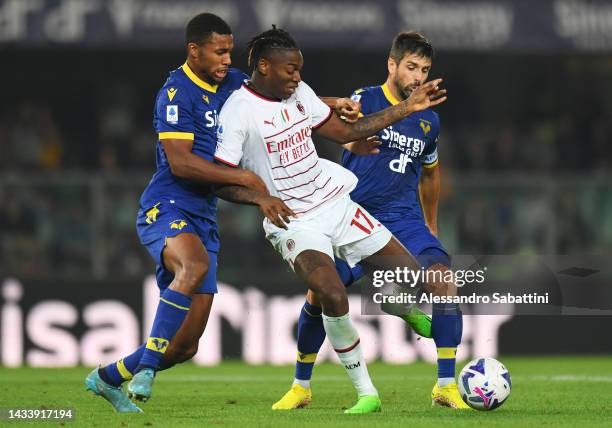 Rafael Leao of AC Milan is challenged by Isak Hien and Miguel Veloso of Hellas Verona during the Serie A match between Hellas Verona and AC MIlan at...