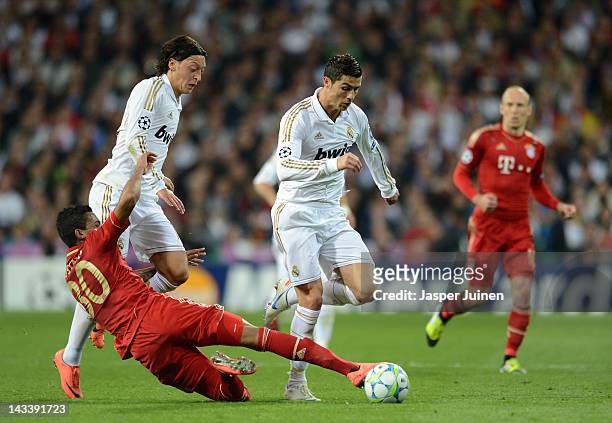Cristiano Ronaldo of Real Madrid evades the tackle of Luiz Gustavo of Bayern Munich during the UEFA Champions League Semi Final second leg between...