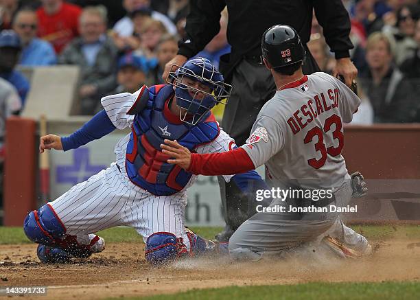 Daniel Descalso of the St. Louis Cardinals scores a run in the third inning as Steve Clevenger of the Chicago Cubs applies the late tag at Wrigley...