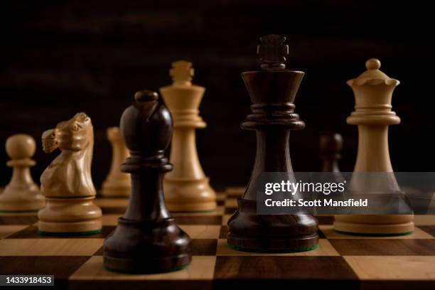 close-up of black chess pieces on a board - spelregels stockfoto's en -beelden