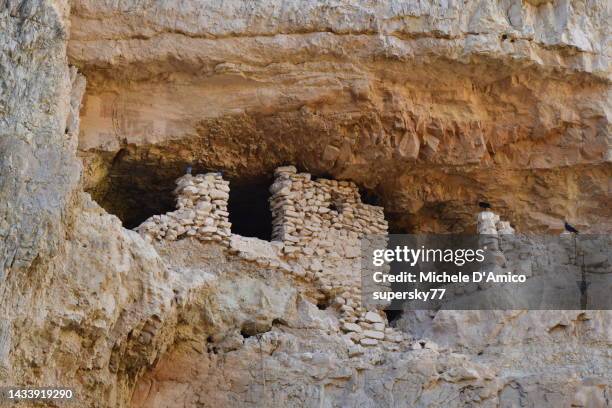 old cave dwelling in the deep desert canyon of wadi qelt - jericho stock pictures, royalty-free photos & images