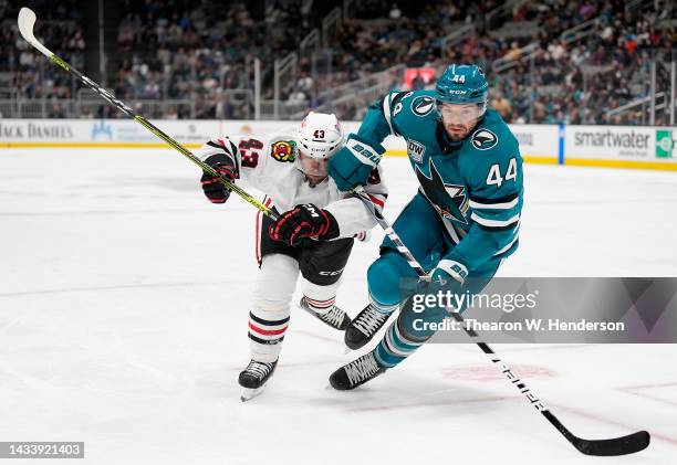 Colin Blackwell of the Chicago Blackhawks and Marc-Edouard Vlasic of the San Jose Sharks races to gain control of the puck during the first period of...