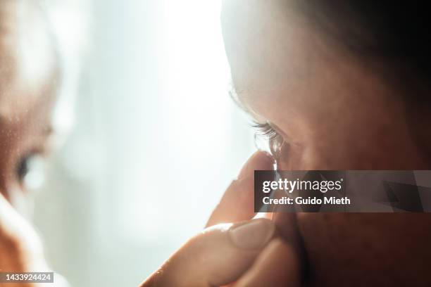 woman putting in contact lens. - lenses bildbanksfoton och bilder