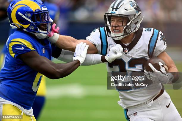 Christian McCaffrey of the Carolina Panthers stiff arms Derion Kendrick of the Los Angeles Rams during the first quarter at SoFi Stadium on October...