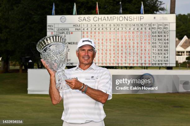 Fred Couples poses with the trophy in front of the leaderboard following the final round of the SAS Championship at Prestonwood Country Club on...