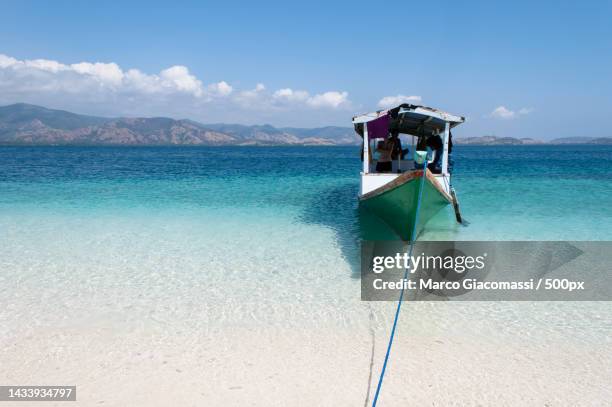 scenic view of tourists on boat in clear blue waters against sky,flores,east nusa tenggara,indonesia - flores indonesia stock pictures, royalty-free photos & images