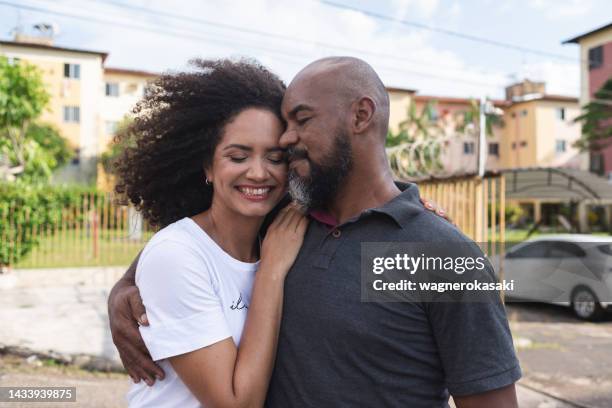 retrato de una pareja adulta sonriente en un condominio residencial - viviendas asequibles fotografías e imágenes de stock