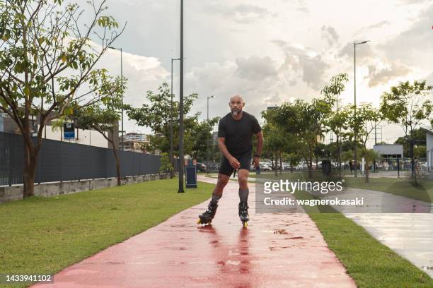 man skating in a public park - inline skating man park stock pictures, royalty-free photos & images