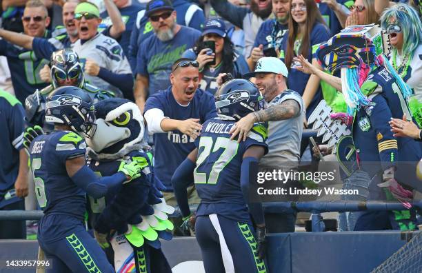 Tariq Woolen of the Seattle Seahawks celebrates an interception against the Arizona Cardinals with fans during the fourth quarter at Lumen Field on...