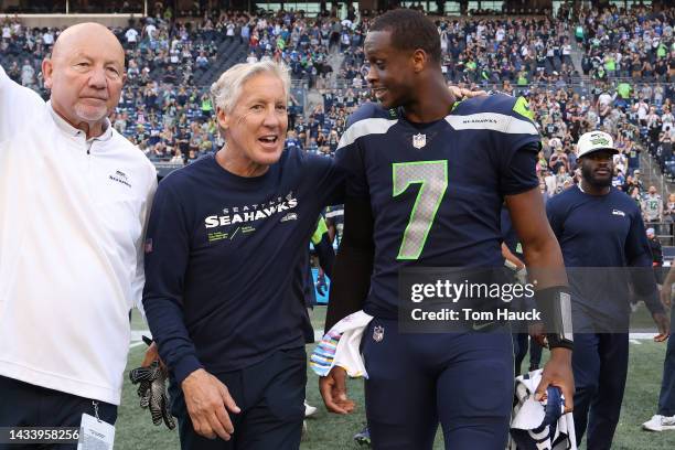 Head coach Pete Carroll of the Seattle Seahawks and Geno Smith celebrate a win against the Arizona Cardinals as they walk off the at Lumen Field on...