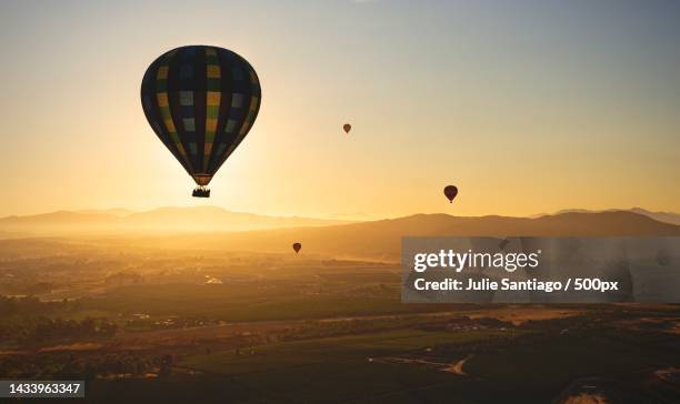 silhouette of hot air balloons flying over landscape against sky during sunset,temecula,california,united states,usa - california valley stock pictures, royalty-free photos & images