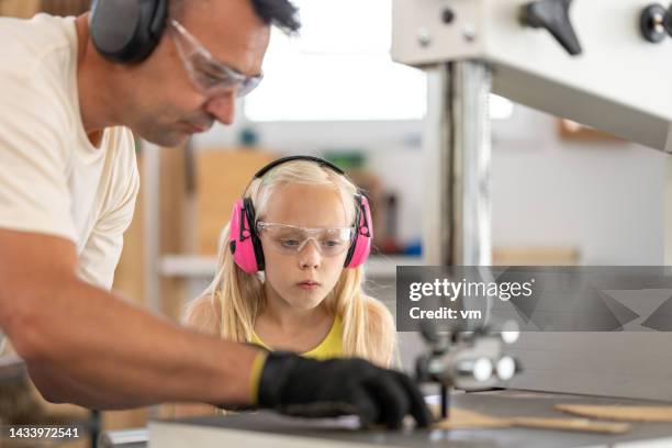 filha e pai cortando madeira, trabalhando com equipamentos de carpintaria elétrica - serra tico tico serra elétrica - fotografias e filmes do acervo