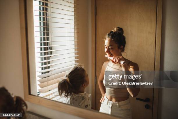 young mother brushing teeth with her little daughter. positive emotions and happiness - man washing his teeth stock-fotos und bilder