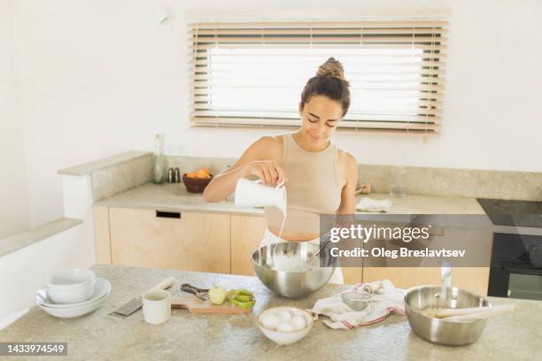 young smiling woman baking apple pie on kitchen. cooking tasty and sweet dessert - gluten free foto e immagini stock