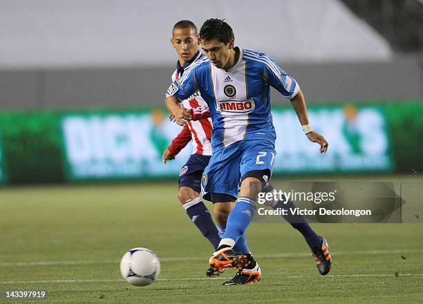 Michael Farfan of Philadelphia Union passes the ball under pressure from Paolo Cardozo of Chivas USA during the MLS match at The Home Depot Center on...