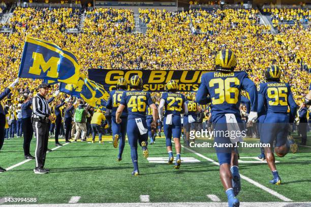 Players of the Michigan Wolverines run onto the field before a college football game against the Penn State Nittany Lions at Michigan Stadium on...