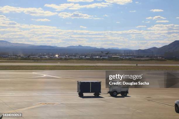 small truck pulling luggage to the airport terminal - luggage trolley stock pictures, royalty-free photos & images