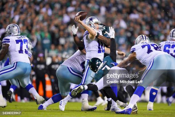 Cooper Rush of the Dallas Cowboys throws a pass whilst being pressured by Javon Hargrave and Haason Reddick of the Philadelphia Eagles during the...