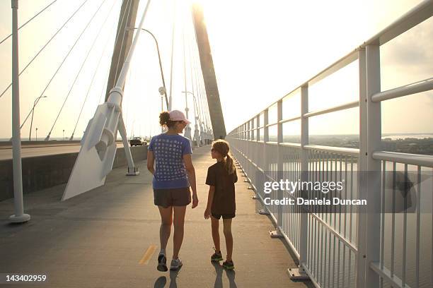 woman and young girl walking on ravenel bridge - charleston south carolina stock-fotos und bilder