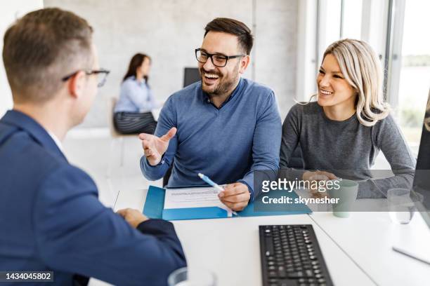 happy couple talking to their insurance agent in the office. - bank manager meeting stock pictures, royalty-free photos & images