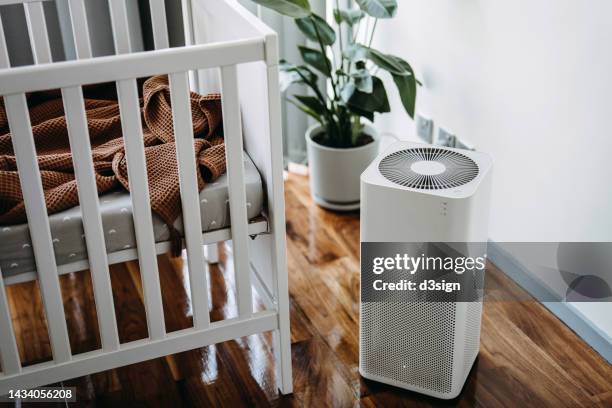 air purifier in the nursery for fresh air. cleaning and removing dust and bacteria. healthier life and living concept - luftfilter stock-fotos und bilder