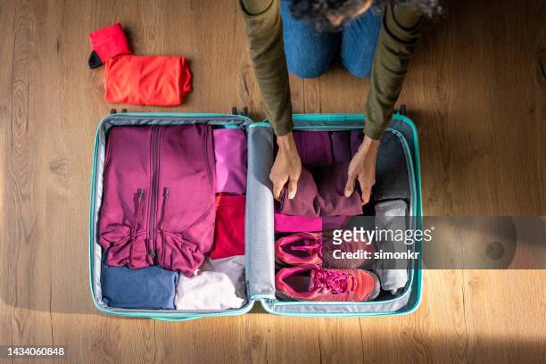 woman packing clothes - suitcase from above stock pictures, royalty-free photos & images