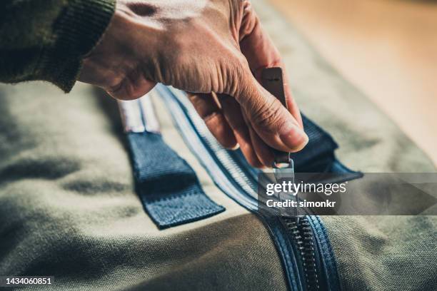 apertura de la mano de la mujer con cremallera del equipaje - zip fotografías e imágenes de stock