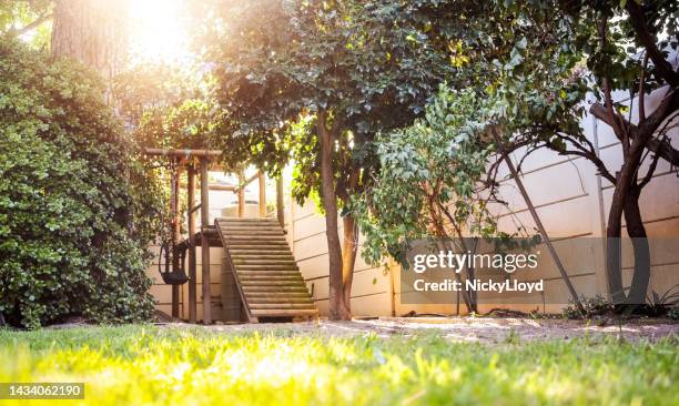 backyard garden with a wooden playhouse - wooden hut stock pictures, royalty-free photos & images