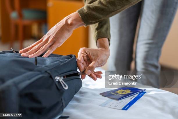 woman's hands closing zip of backpack - self closing stockfoto's en -beelden