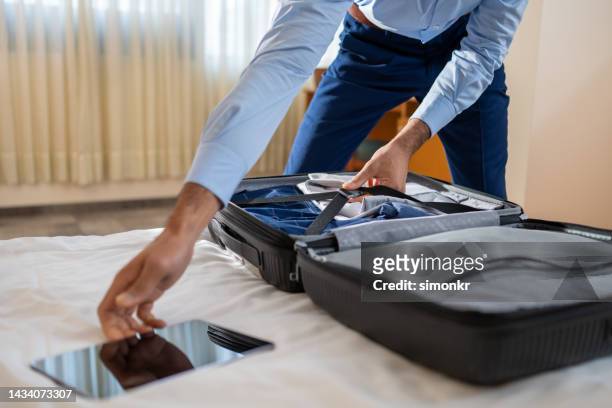 mann packt kleidung - kofferband stock-fotos und bilder