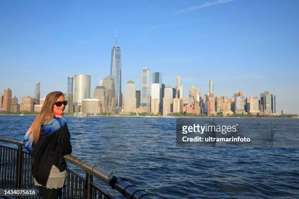 pretty  active women long blonde hair enjoying  in  panorama of new york city skyline lower manhattan - albany new york stock pictures, royalty-free photos & images