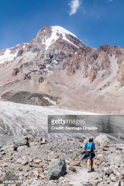 hiker climbing to the glacier of mount kazbek - montagnes du caucase photos et images de collection