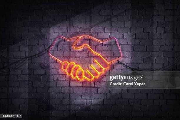 hand shake in neon style - willkommen schild stock-fotos und bilder