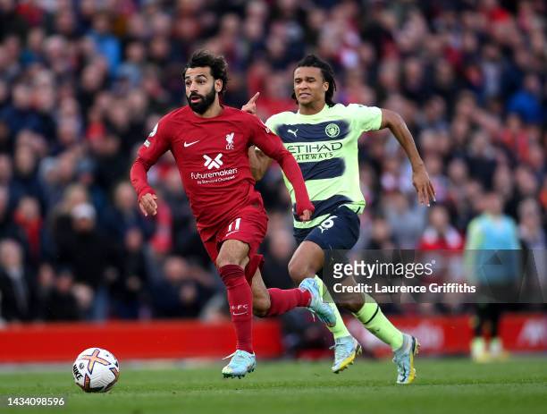 Mohamed Salah of Liverpool breaks past Nathan Ake of Manchester City during the Premier League match between Liverpool FC and Manchester City at...