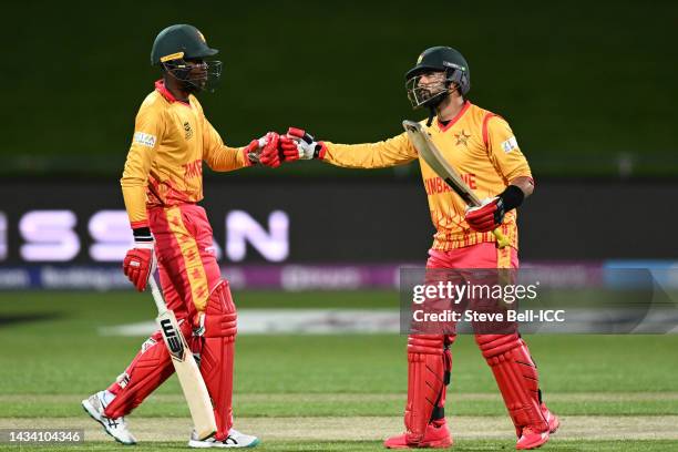 Sikandar Raza of Zimbabwe is congratulated by Milton Shumba of Zimbabwe after reaching their half century during the ICC Men's T20 World Cup match...