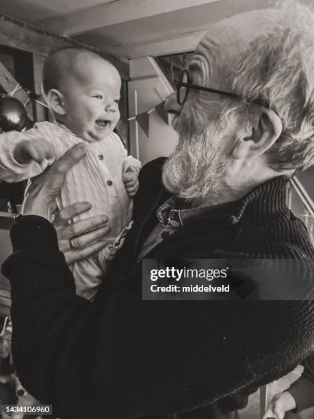 stolzer großvater mit baby-enkel - baby father hug side stock-fotos und bilder