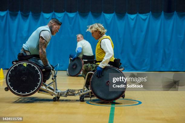 gelb versus blau - wheelchair rugby stock-fotos und bilder