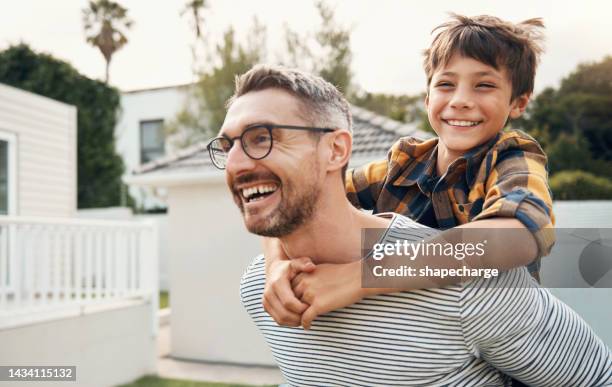 jeu de ferroutage, père et enfant dans le jardin de leur maison avec sourire, détente et bonheur en été. jeune enfant heureux et calme jouant avec son père dans l’arrière-cour de leur maison avec amour - family smile photos et images de collection