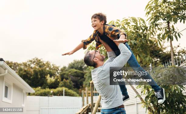 man, kid and lift in air in garden, backyard or outdoor at house while play by trees, father, boy and love while bonding, fun and happy time together at family, vacation or holiday in orlando - family time stock pictures, royalty-free photos & images