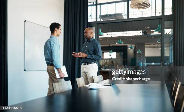 leadership dell'uomo d'affari che parla al dipendente come mentore, coaching e formazione in società aziendale, pianificazione dell'ufficio o discussione. manager nero assertivo che parla in conversazione con il personale in avvio - irriducibilità foto e immagini stock